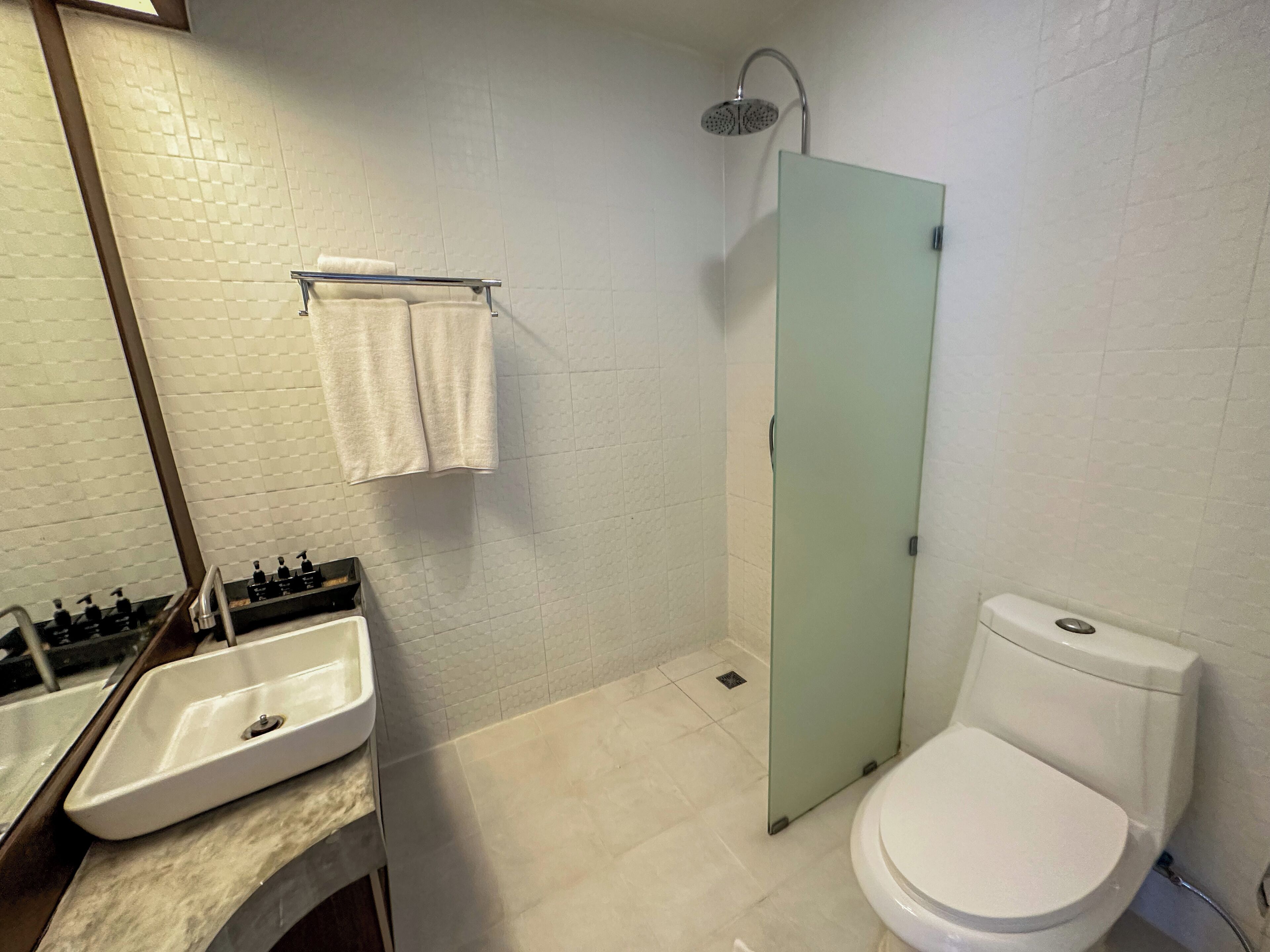 A bathroom with a sink, toilet, and shower.