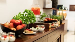 A buffet table with various food items and a drink. - Hotel Vier Jahreszeiten Starnberg (Starnberg)