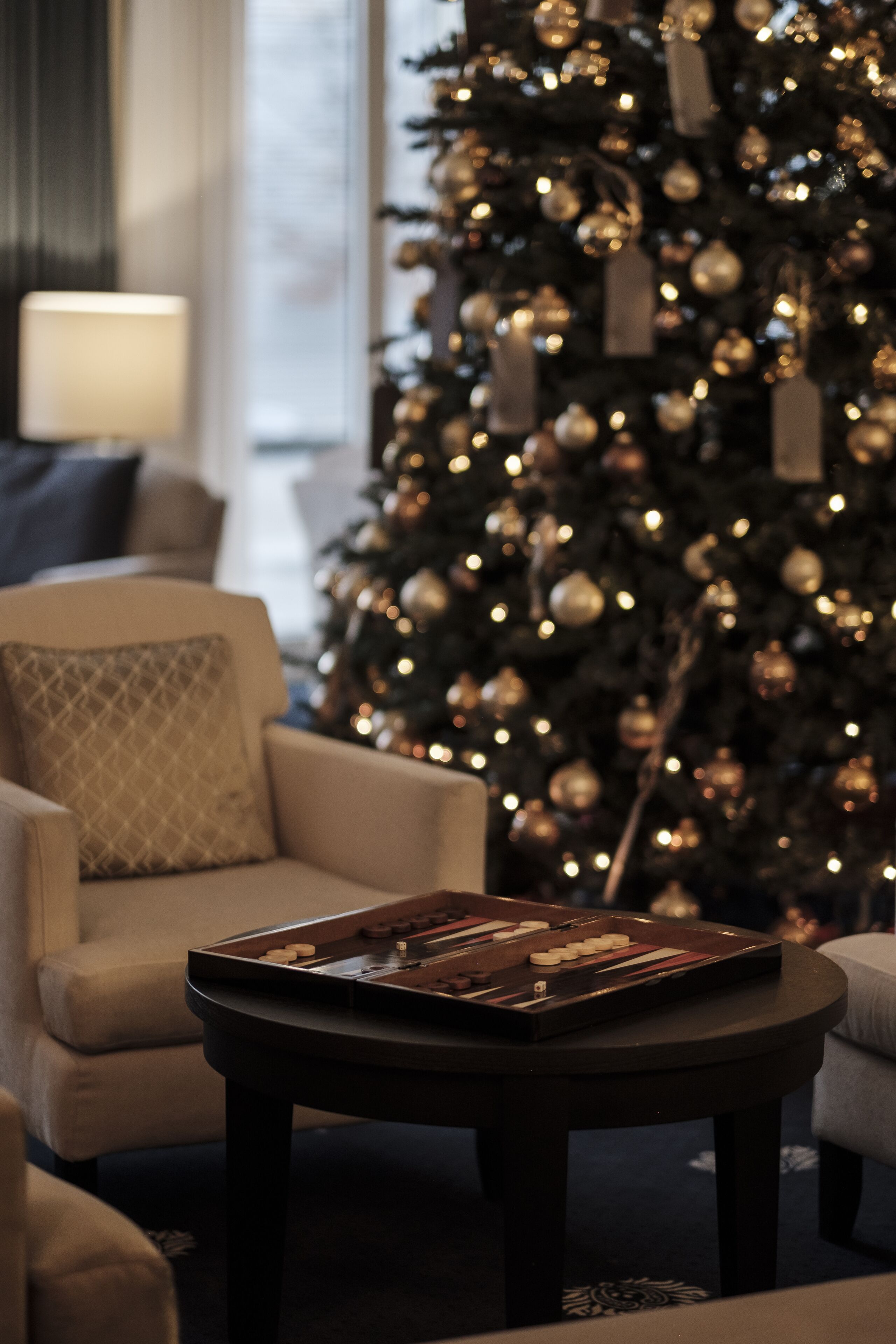 A cozy living room with a Christmas tree, a coffee table, and a sofa.