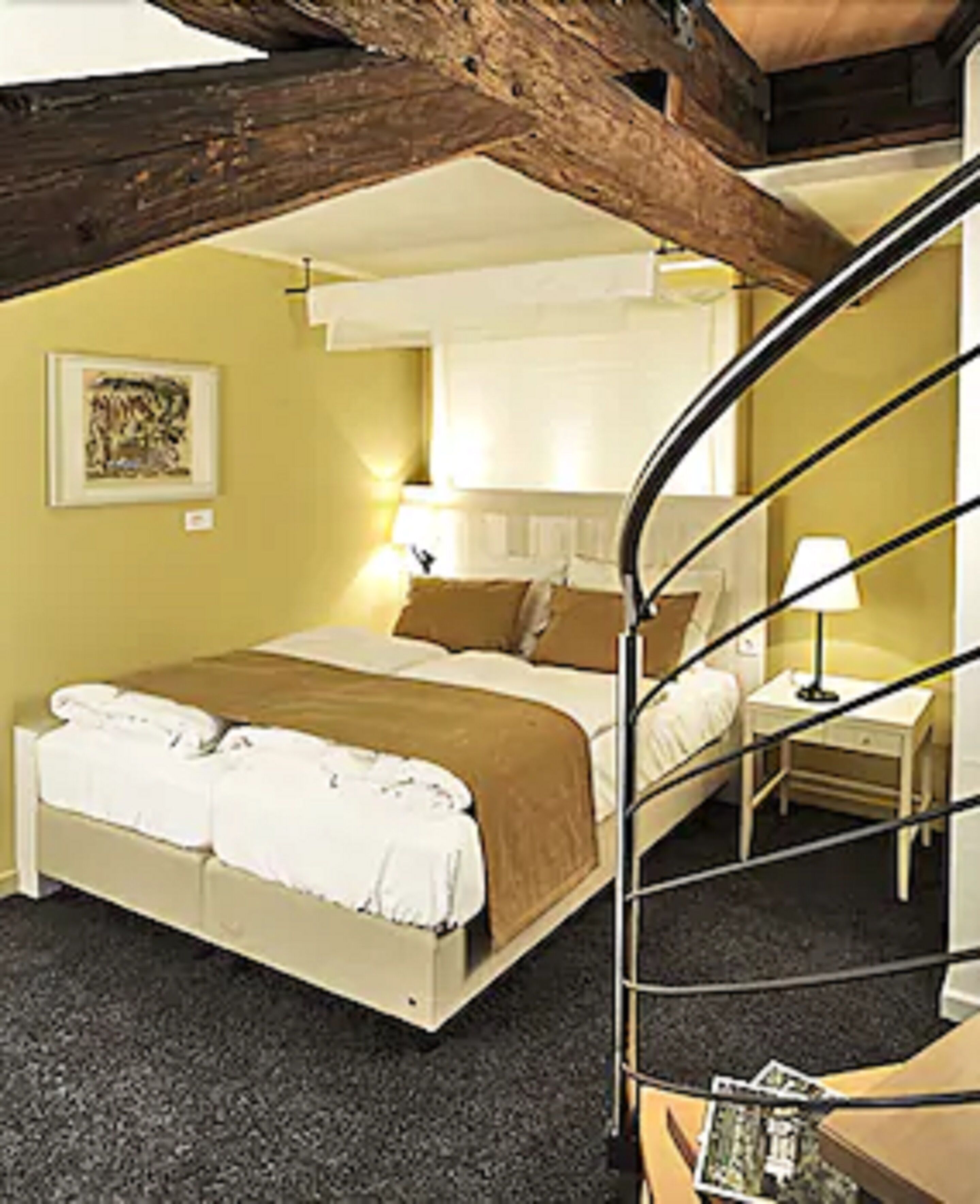 Um quarto com uma cama, uma mesa de cabeceira, um abajur e um quadro na parede.