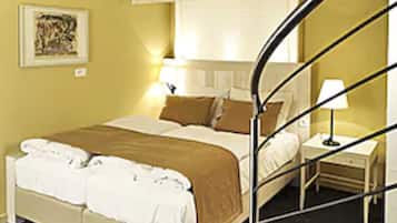 Um quarto com uma cama, uma mesa de cabeceira, um abajur e um quadro na parede.