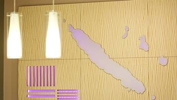 Eine Wand mit einer Kartenumrisssilhouette, hängenden Pendelleuchten und dekorativen Musterelementen.