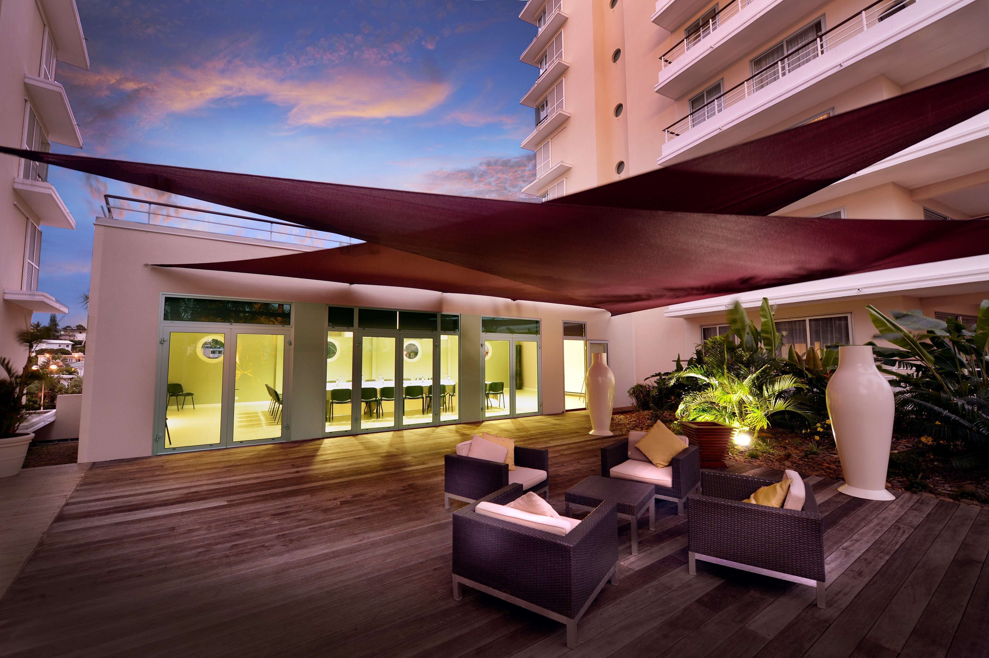 An outdoor lounge area with seating and a view of the building's interior.