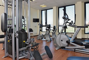 A gym with various exercise equipment including treadmills, elliptical machines, and weight machines. - Best Western Plus Konrad Zuse Hotel (Huenfeld)