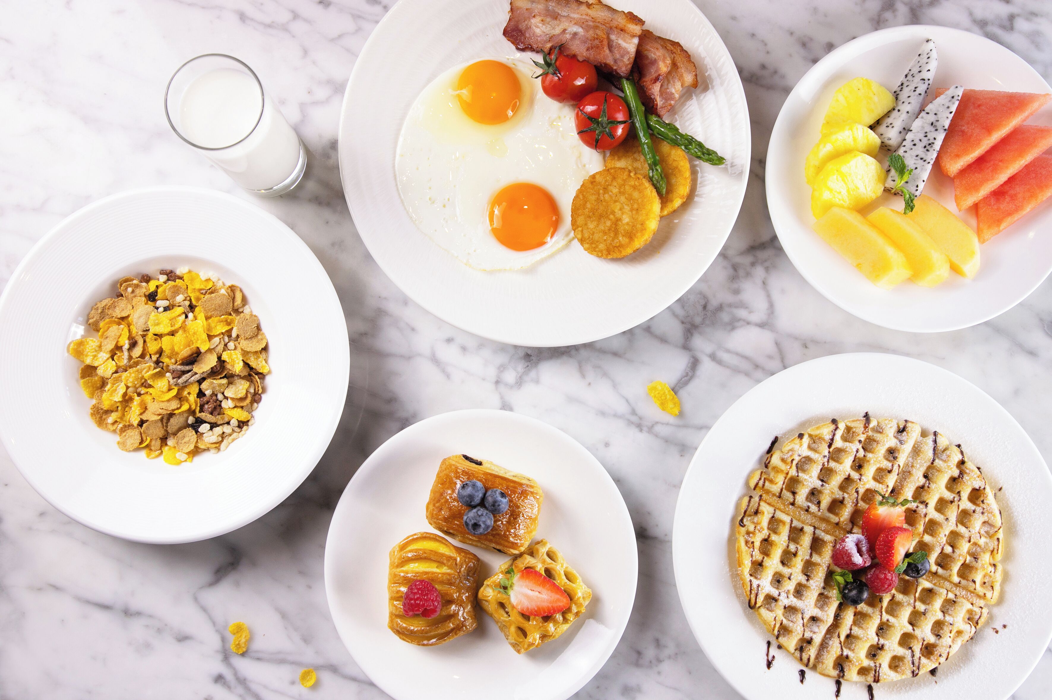 A breakfast spread with various dishes including eggs, bacon, and fruits.
