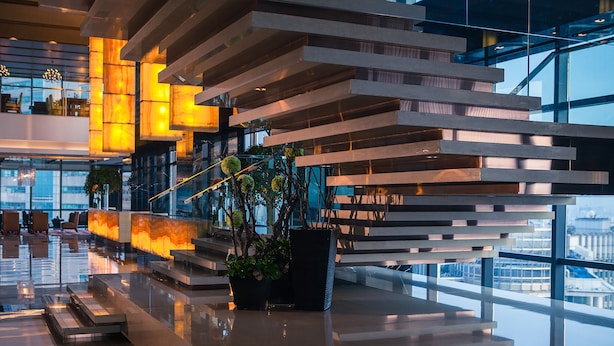 A modern interior with reflective floors, a staircase, and potted plants. - Renaissance Shanghai Zhongshan Park Skyline Hotel (Shanghai)