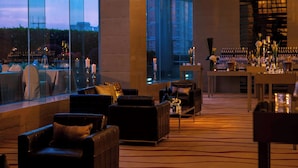A modern hotel lobby with leather seating, a bar area, and large windows offering a city view. - Renaissance Shanghai Zhongshan Park Skyline Hotel (Shanghai)