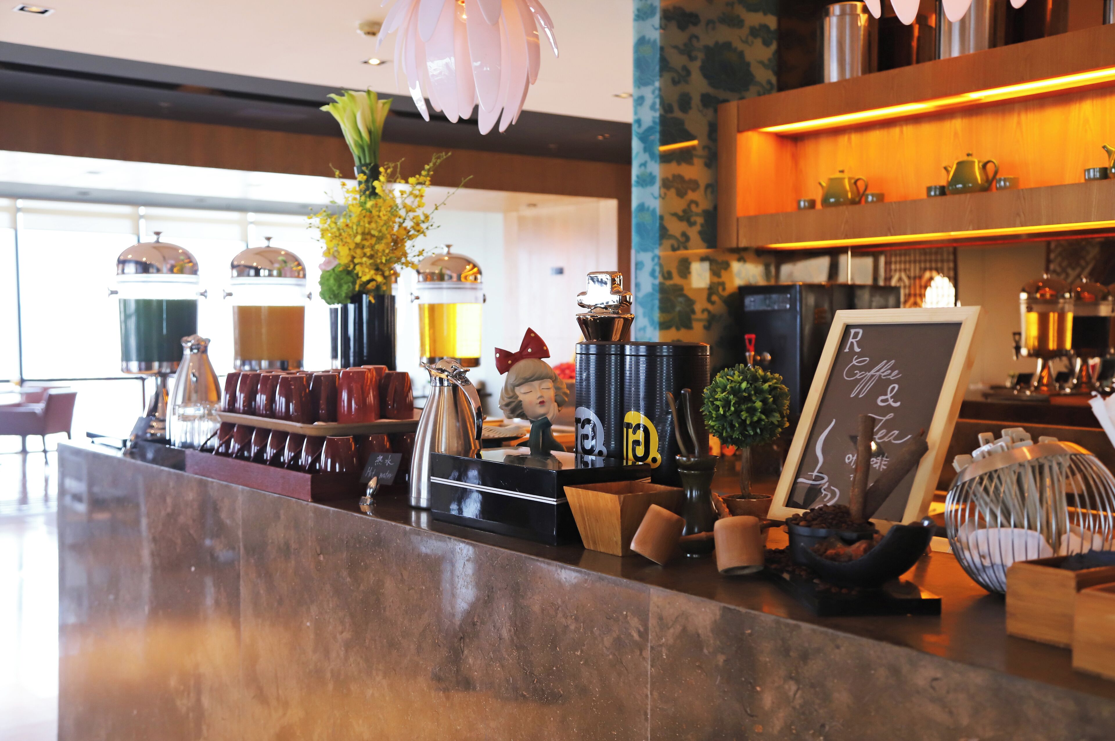 A bar area with a coffee machine, tea kettle, and a chalkboard menu.
