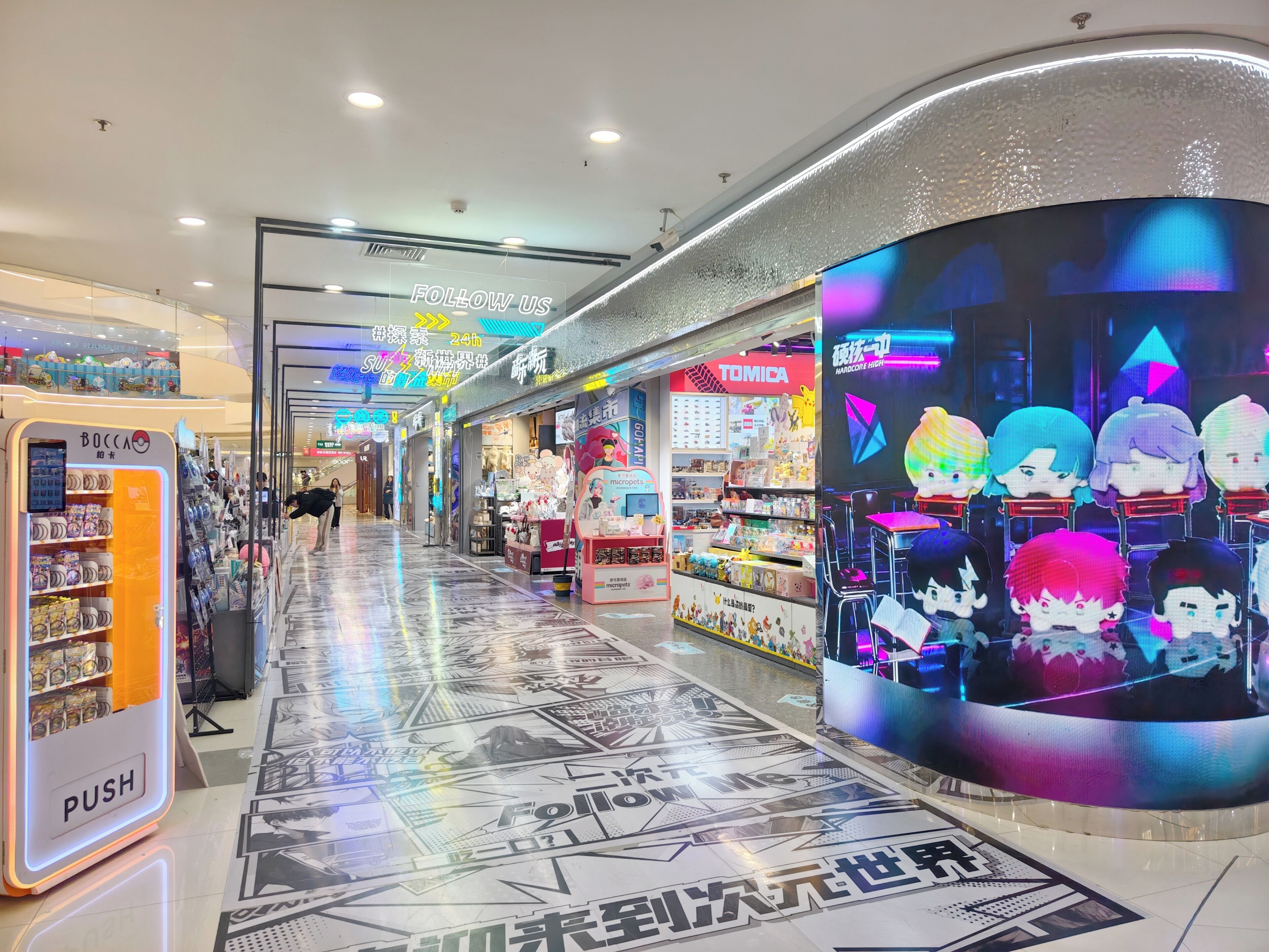 A corridor with a vending machine, a store with colorful displays, and a digital screen with animated characters.