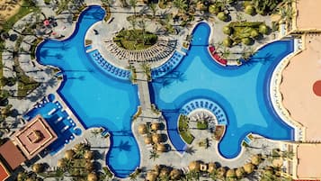Relax by the resort's unique guitar-shaped pool surrounded by palm trees and sun loungers.