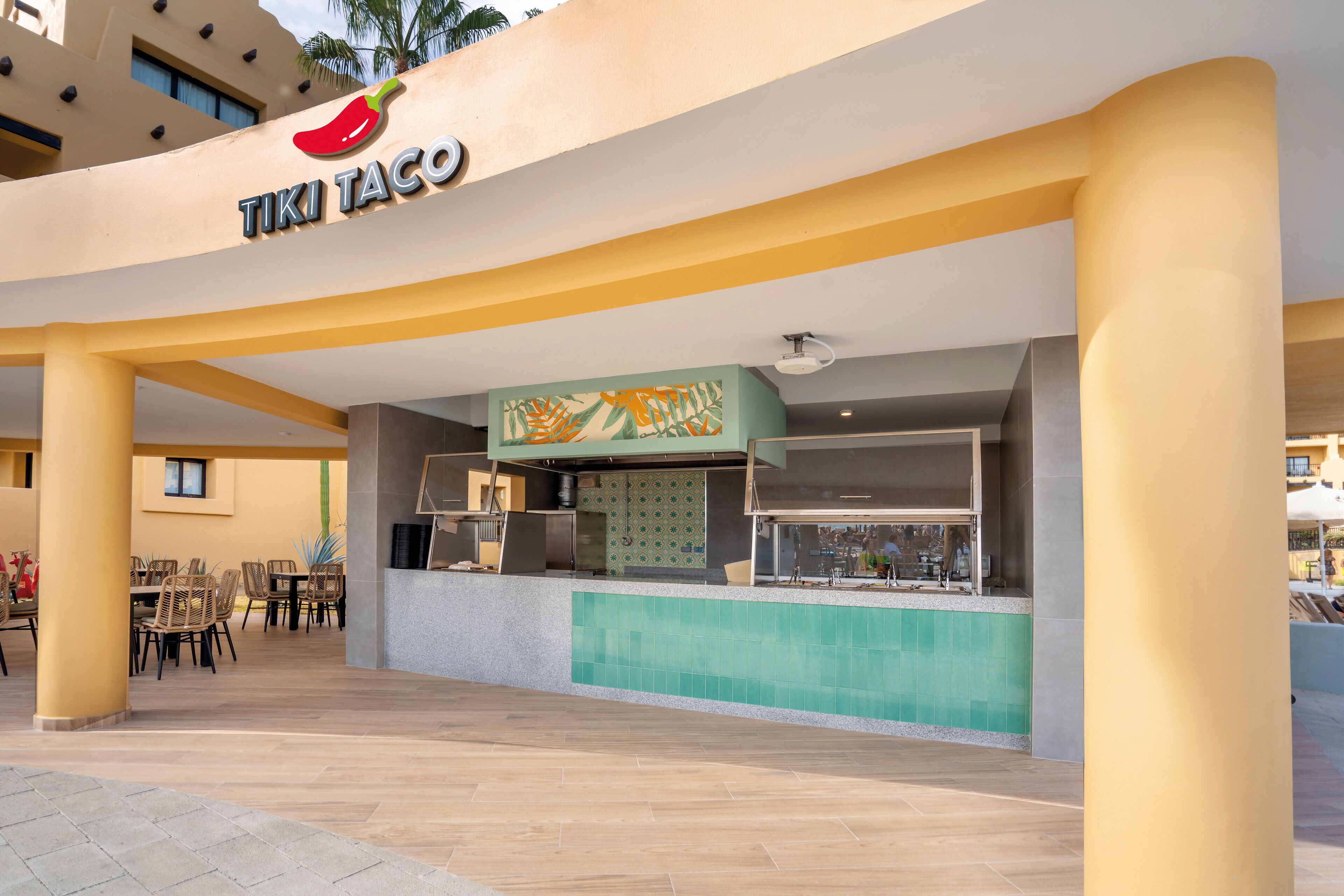 A TIKI TACO restaurant with outdoor seating and a pool area.