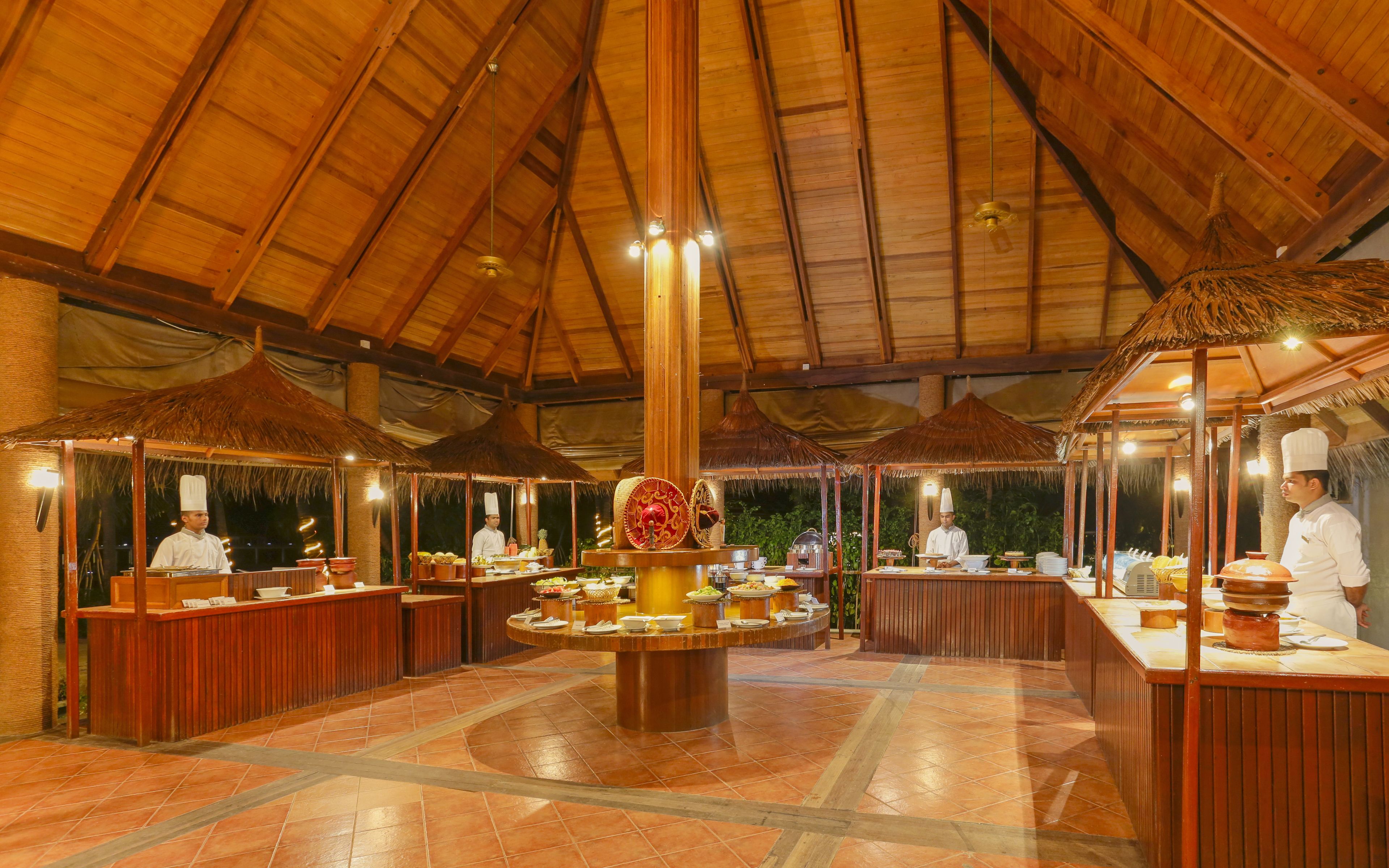 Un restaurant doté d’un haut plafond en bois et de toits en chaume.