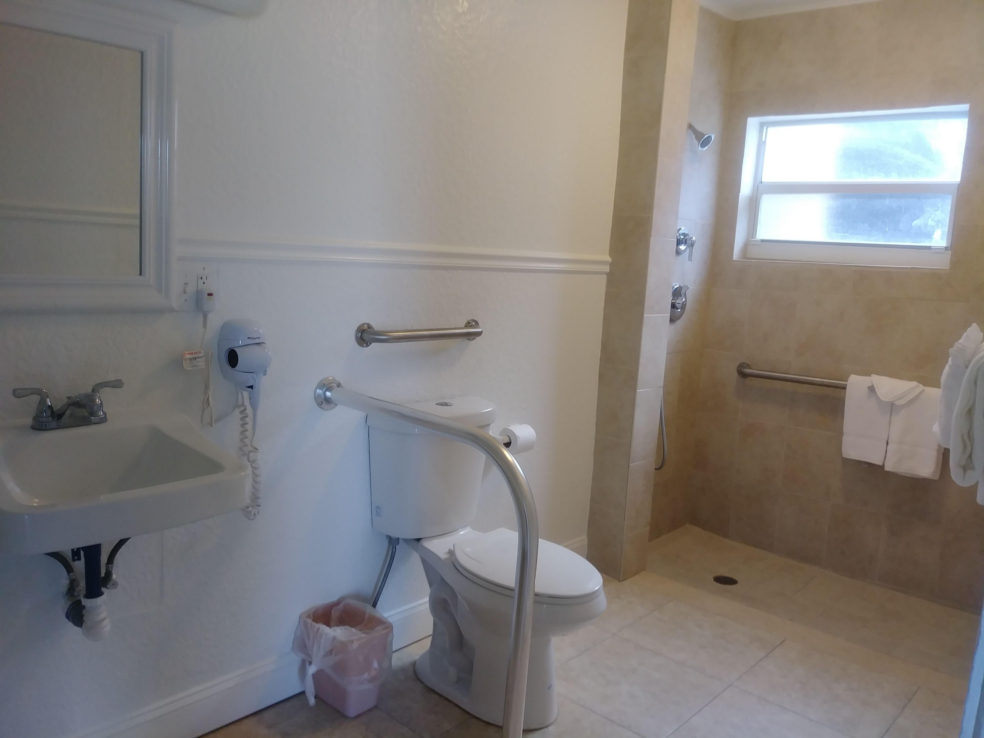 A bathroom with a toilet, sink, and shower area.
