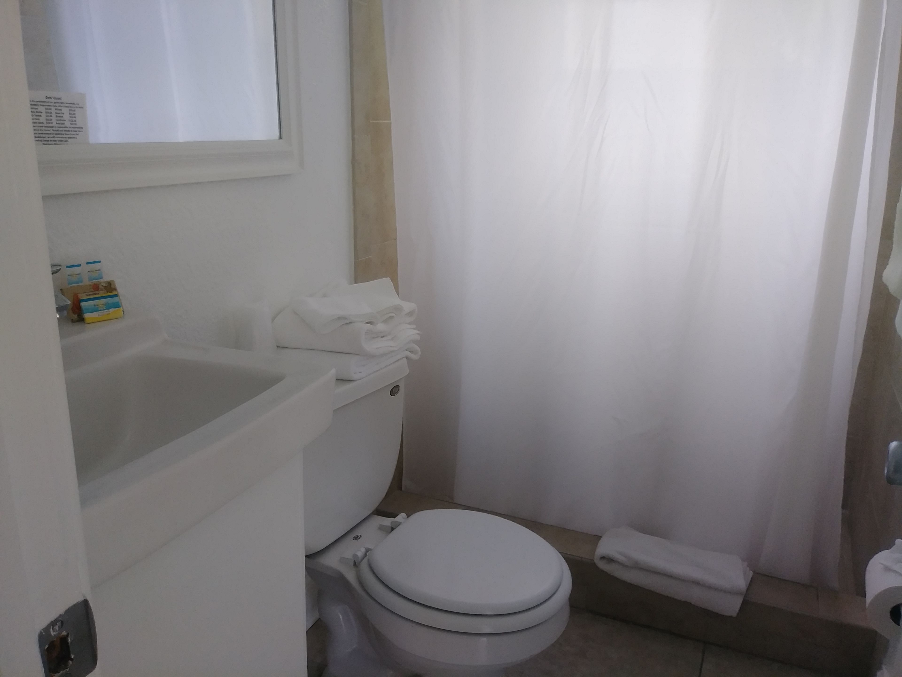 A bathroom with a toilet, a sink, and a shower curtain.