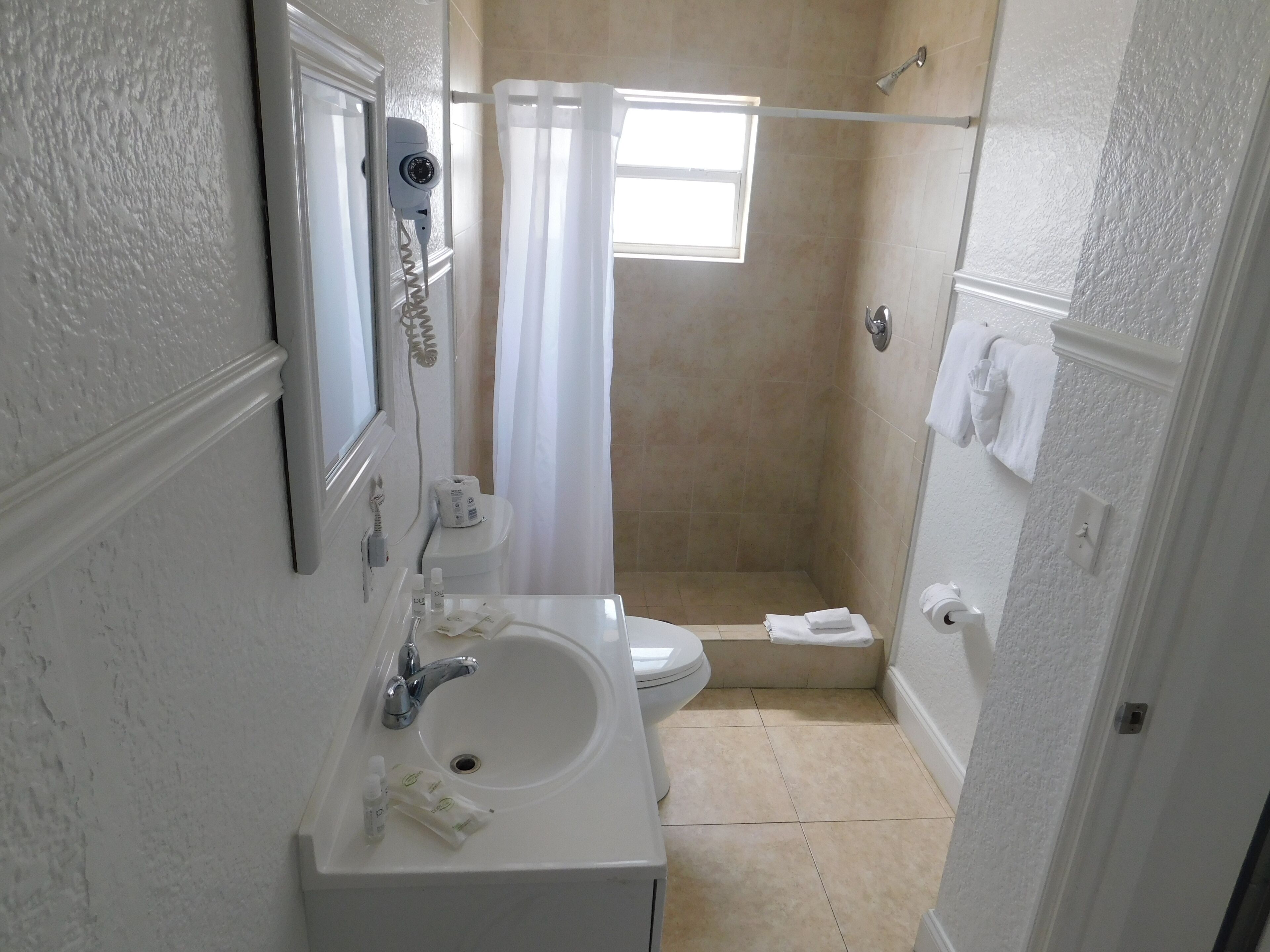 A bathroom with a sink, toilet, and shower area.