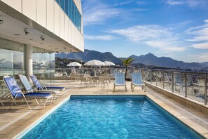 A rooftop pool with lounge chairs and umbrellas, overlooking a mountainous landscape. - Windsor Asturias Hotel (Rio de Janeiro)
