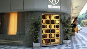 Un restaurante con un toldo distintivo y una entrada grande e iluminada.