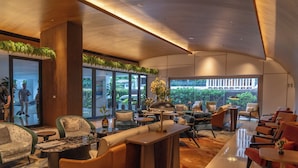 A modern hotel lobby with a curved ceiling, large windows, and a variety of seating options including sofas and chairs. - Fraser Suites Sukhumvit, Bangkok (Bangkok)