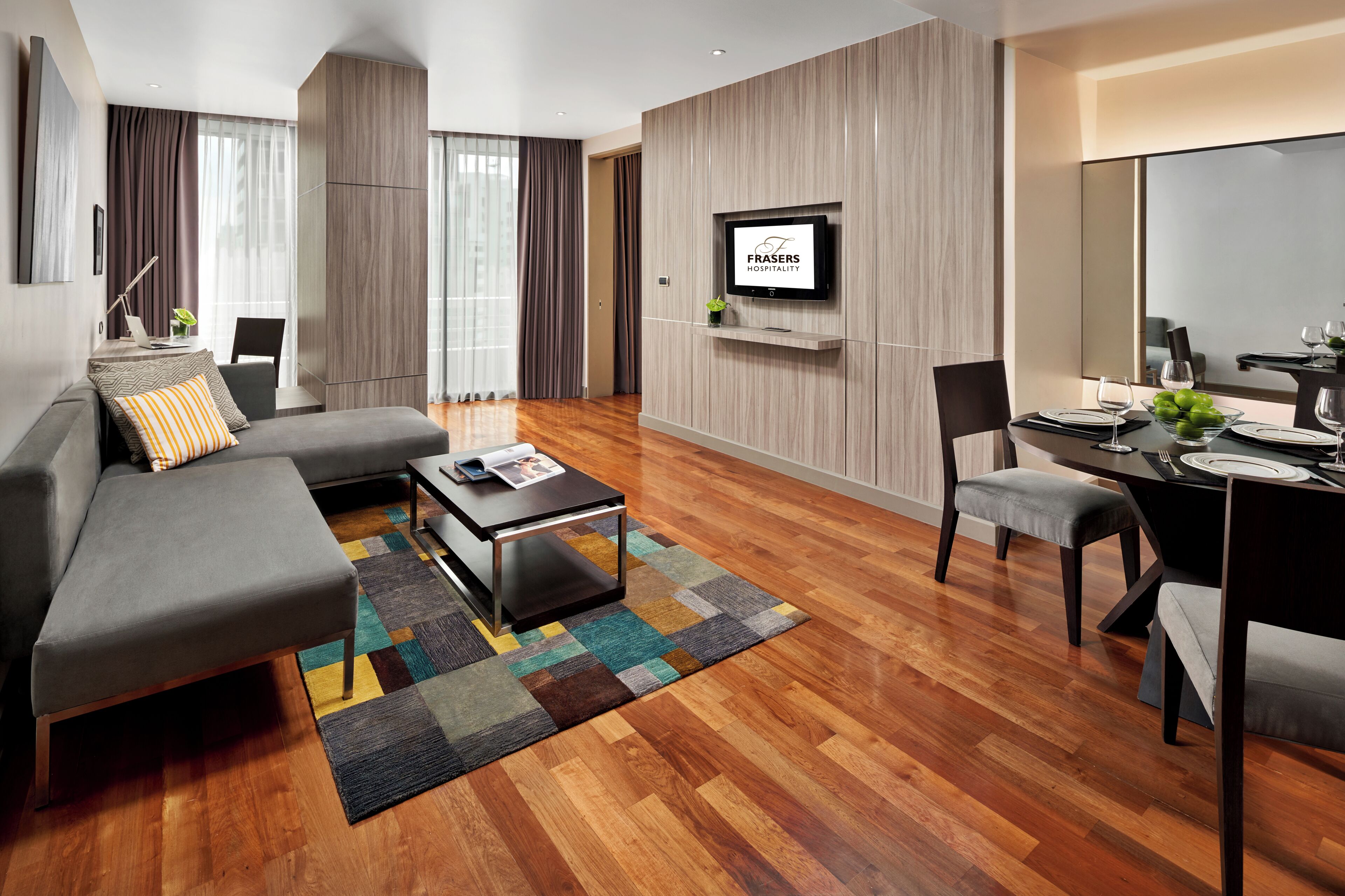 Un salon moderne comprenant un canapé, une table basse et un coin repas avec une chaise et une table.