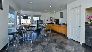 Una cocina moderna con barra, que incluye taburetes de acero inoxidable, un ventanal y vistas al exterior.