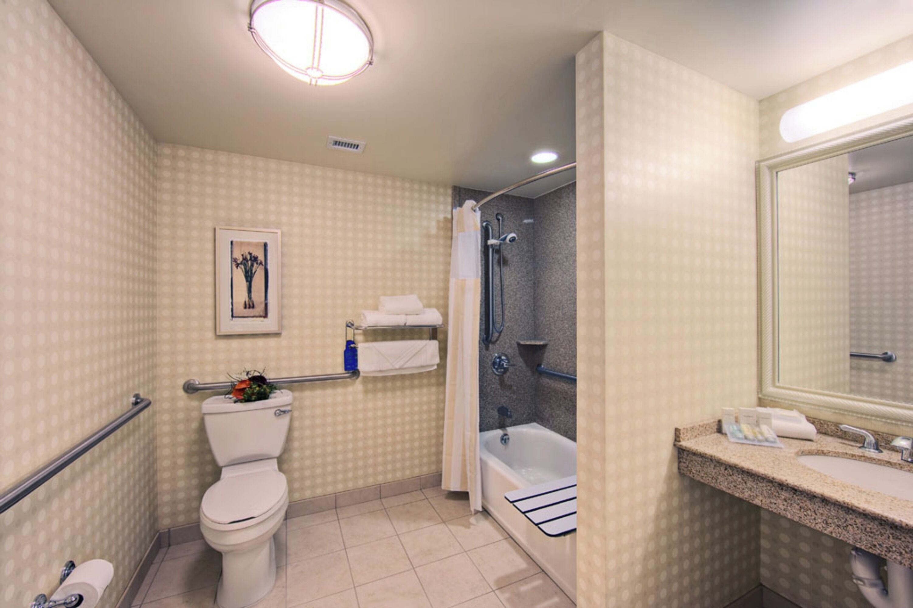 A bathroom with a toilet, shower, and sink.