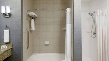 A modern bathroom with a walk-in shower, a bathtub, and a vanity with a towel rack.
