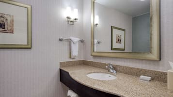 A bathroom with a sink, mirror, towel rack, and framed pictures on the wall.