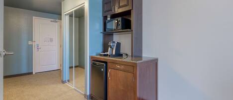 A compact kitchen with a microwave, coffee maker, and dishwasher.