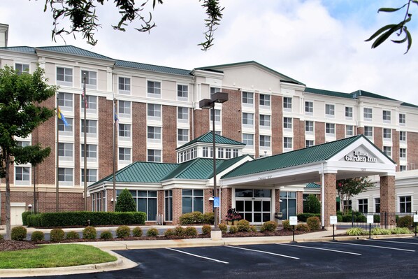 Classic hotel entrance with a covered walkway and beautifully maintained grounds.