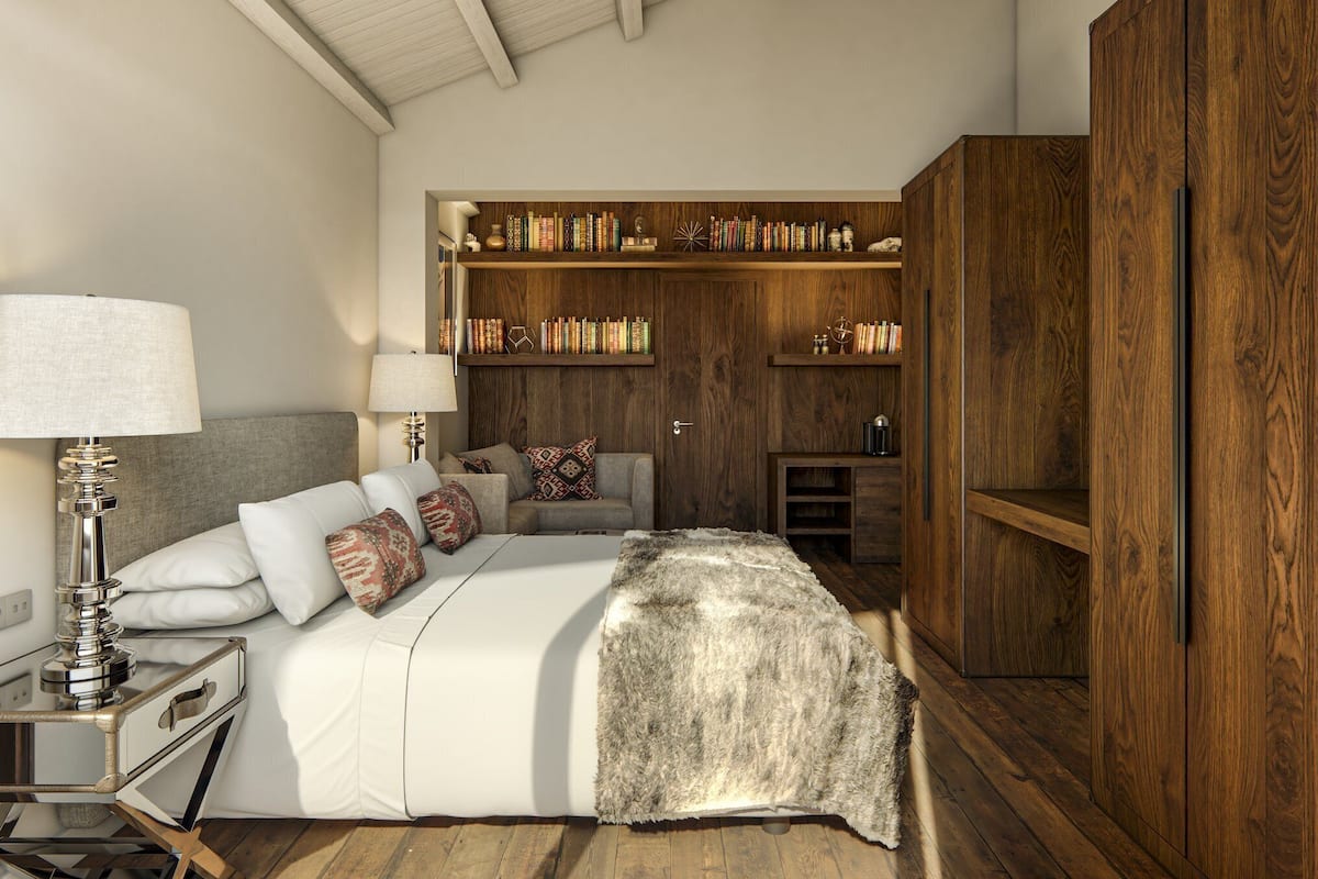 Un dormitorio con cama, mesitas de noche, lámpara, armario y estanterías empotradas.