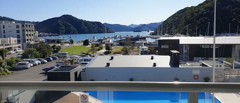 Vista de un puerto deportivo con barcos, una piscina y un edificio con un letrero de prohibido fumar.