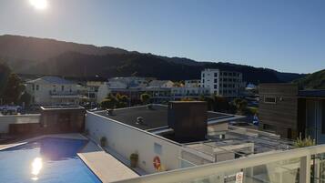 Una piscina en la azotea con vistas despejadas a edificios circundantes y una montaña al fondo.