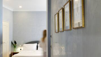 A hotel room with a bed, bedside table, and wall-mounted picture frames.