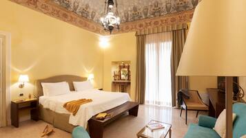 Suite Junior, 1 letto king, balcone, vista mare parziale | Biancheria da letto di alta qualità, copriletto in piuma, minibar