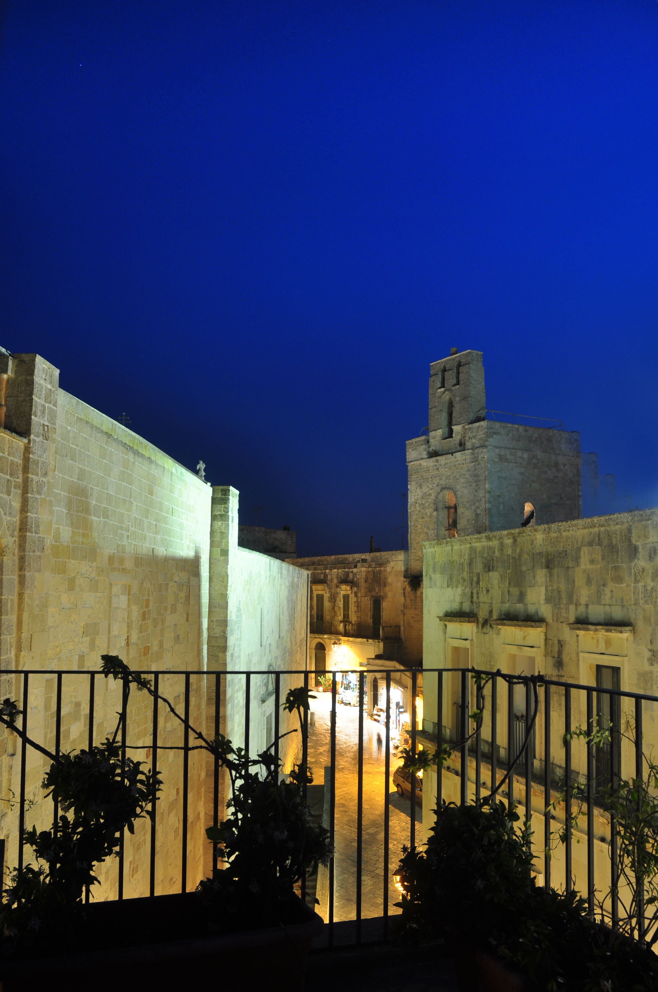 Un cortile con edifici in pietra, un cancello e una torre.