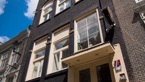 A two-story building with a black facade and cream-colored doors and windows. - Amsterdam Downtown Hotel (Amsterdam)