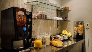 A coffee machine, glassware, and breakfast items on a buffet counter. - Amsterdam Downtown Hotel (Amsterdam)