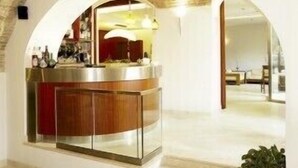 A modern kitchen with a central island, an arched doorway, and a visible dining area. - Hotel Italia (Foligno)