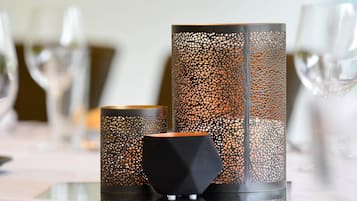 Three candle holders with intricate cut-out patterns on a table.