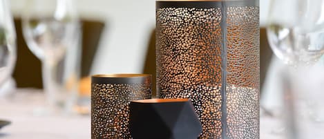 Three candle holders with intricate cut-out patterns on a table.