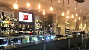 Eine Bar mit einer Minibar, Barhocker und einer Auswahl an Spirituosenflaschen.