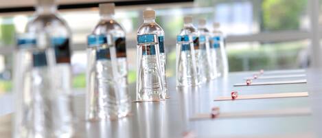 A row of clear plastic water bottles with blue labels on a table.