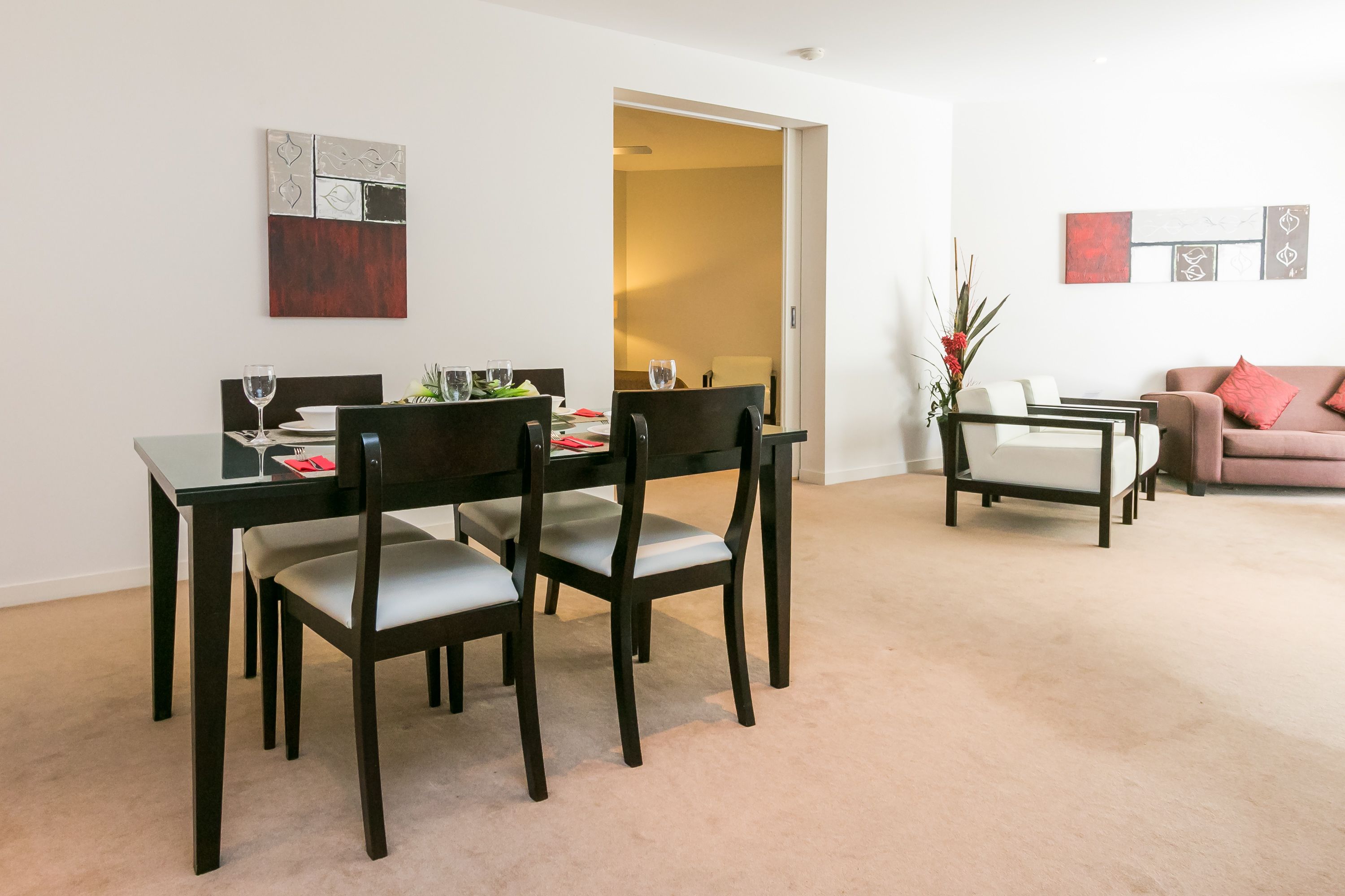 A dining area with a table and chairs, a sofa, and a coffee table in a modern interior.