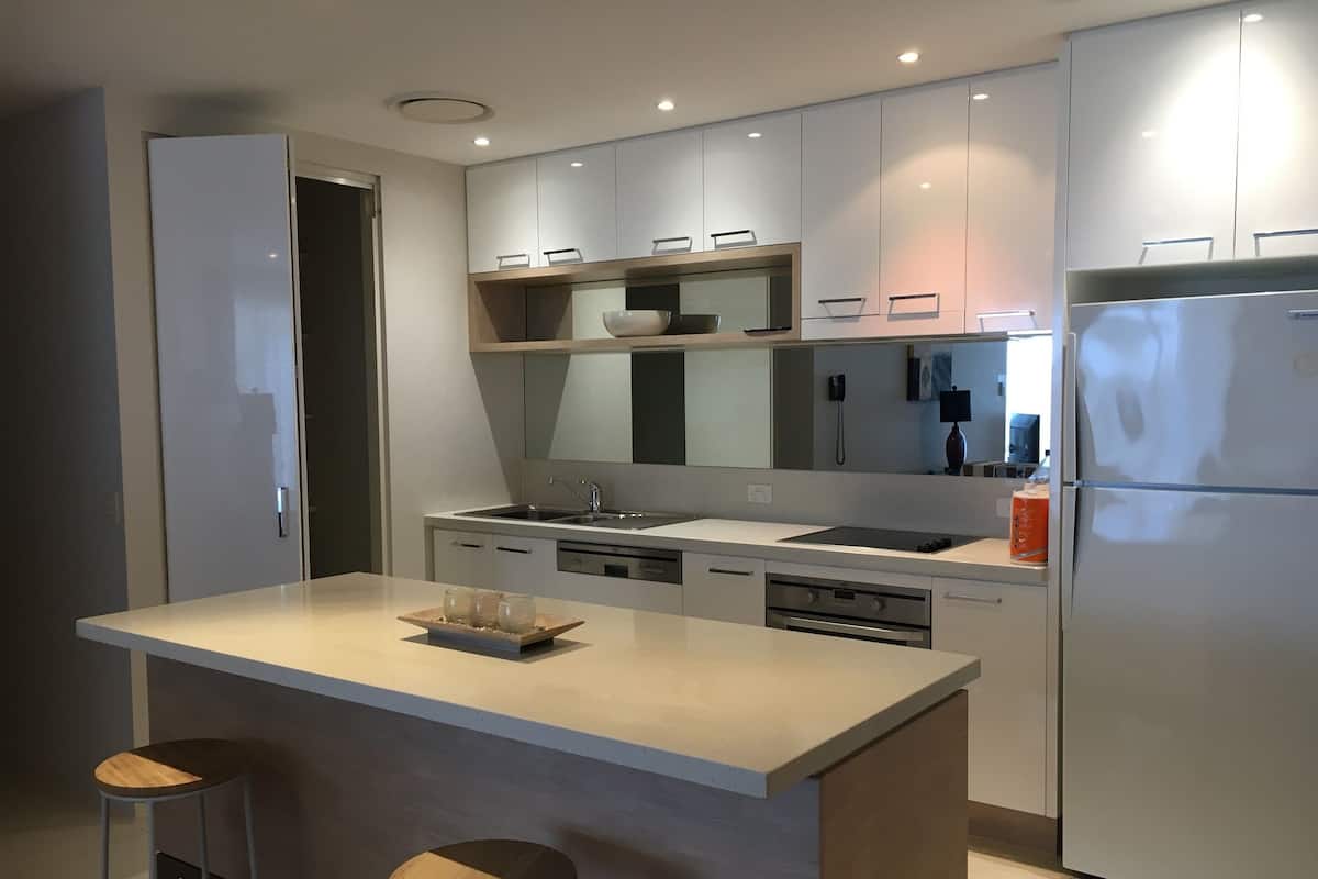 A modern kitchen with a central island, built-in appliances, and a minimalist design.