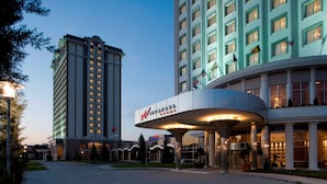 A hotel with a prominent curved entrance and a tall adjacent building. - WOW Istanbul Hotel (Istanbul)