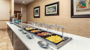 A buffet with various food items and framed artwork on the wall. - Hawthorn Extended Stay by Wyndham West Palm Beach Airport (West Palm Beach)