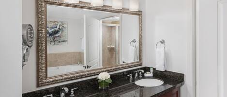 A bathroom with two sinks, a large mirror, and a vanity cabinet.