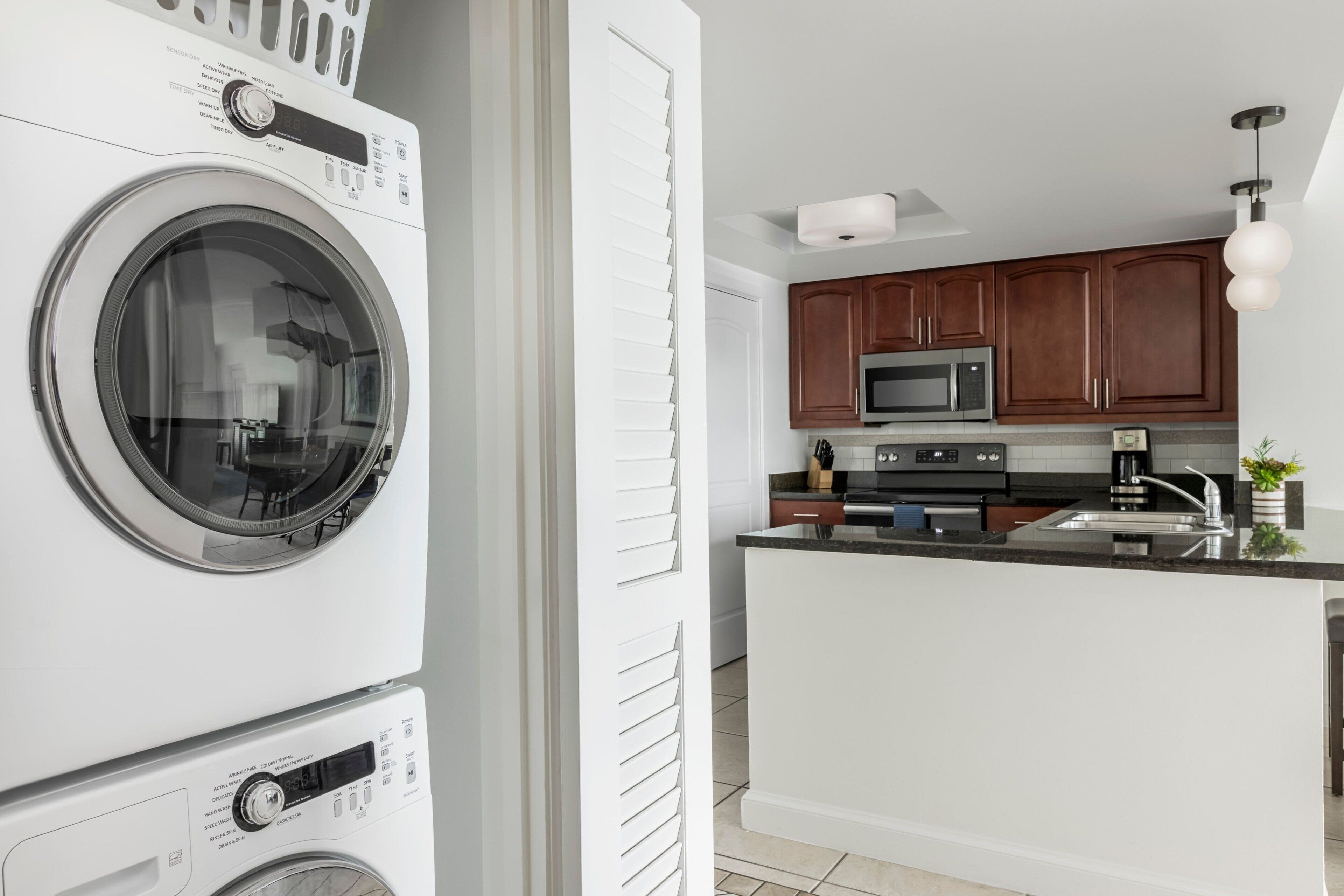A modern kitchen with wooden cabinets, a microwave, and a built-in oven.