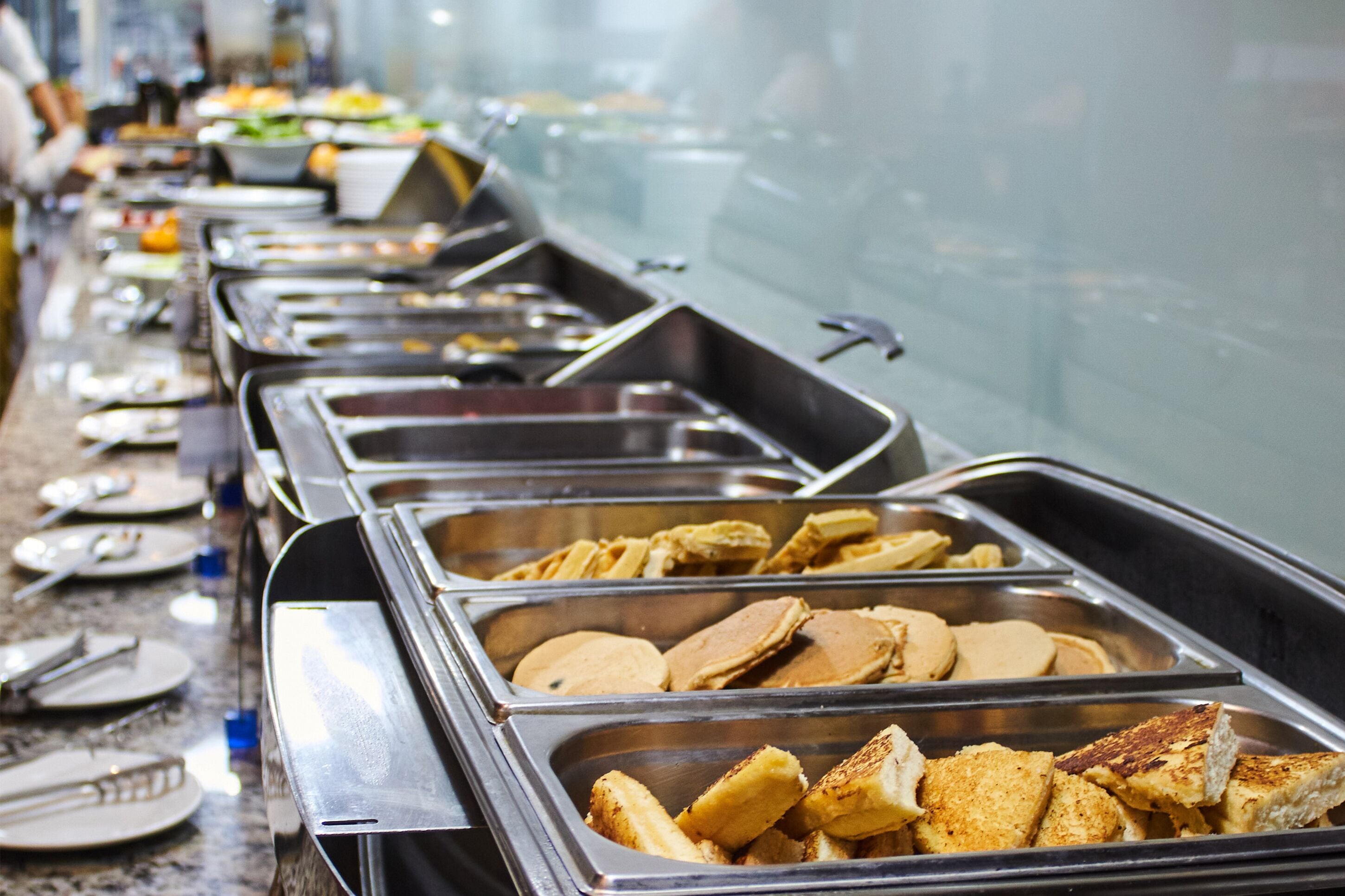 A buffet with various food items including pancakes and toast.