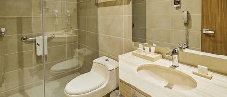 A modern bathroom with a glass-enclosed shower, a toilet, a sink with a vanity, and a mirror.